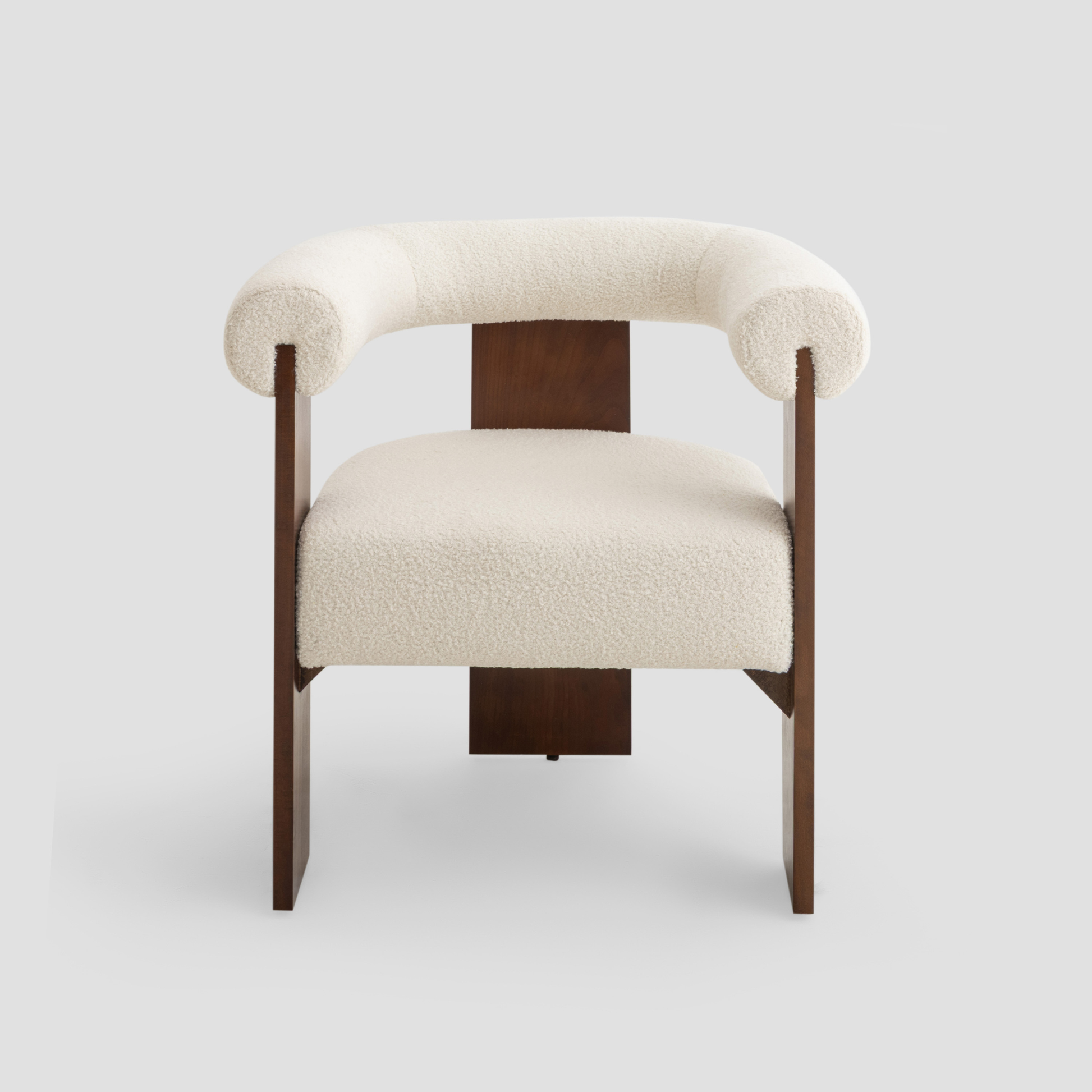 Ruby Curved Armchair in beech wood, featuring modern armchair and scandinavian styling, with cream and reading.