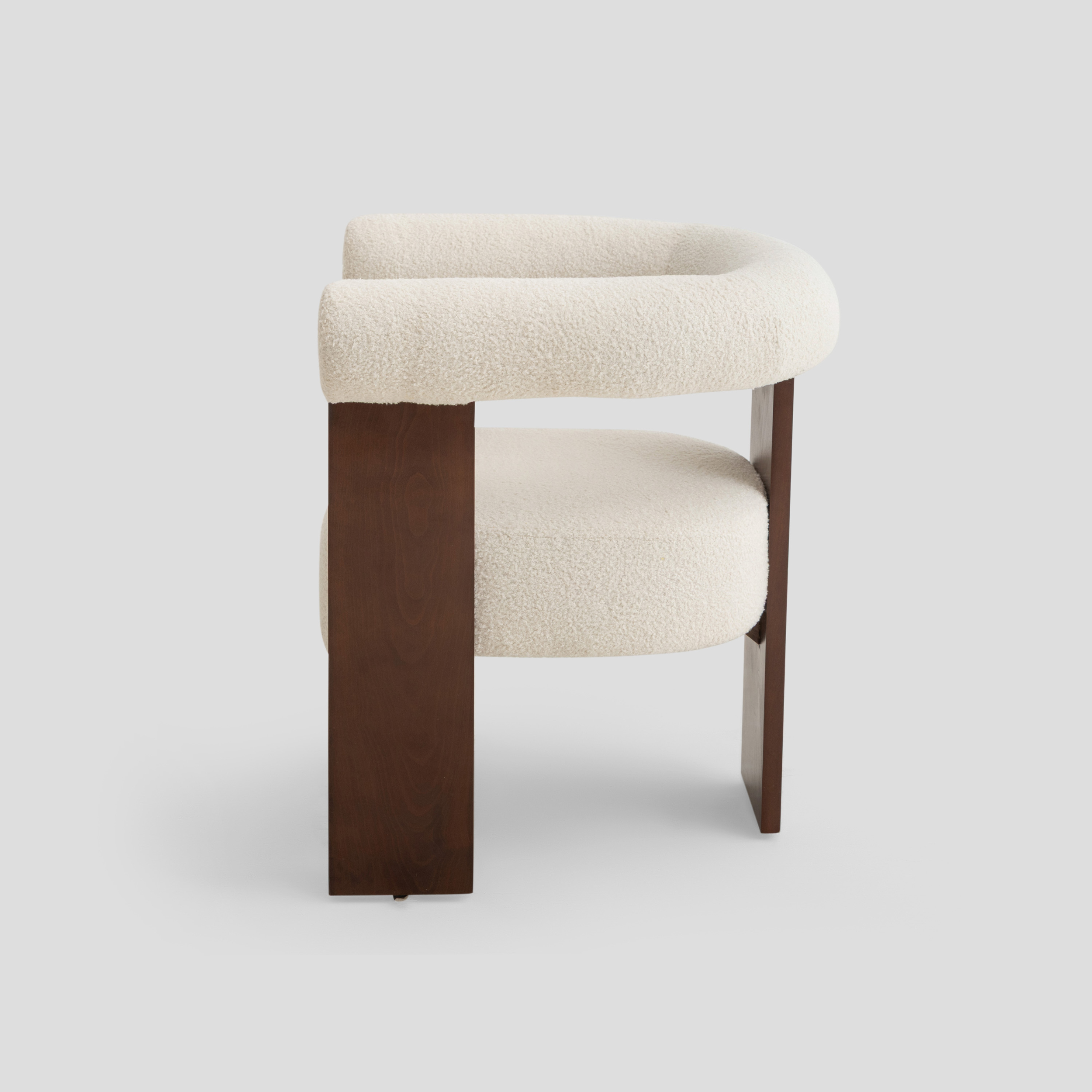 Ruby Curved Armchair in beech wood, featuring modern armchair and scandinavian styling, with cream and reading.
