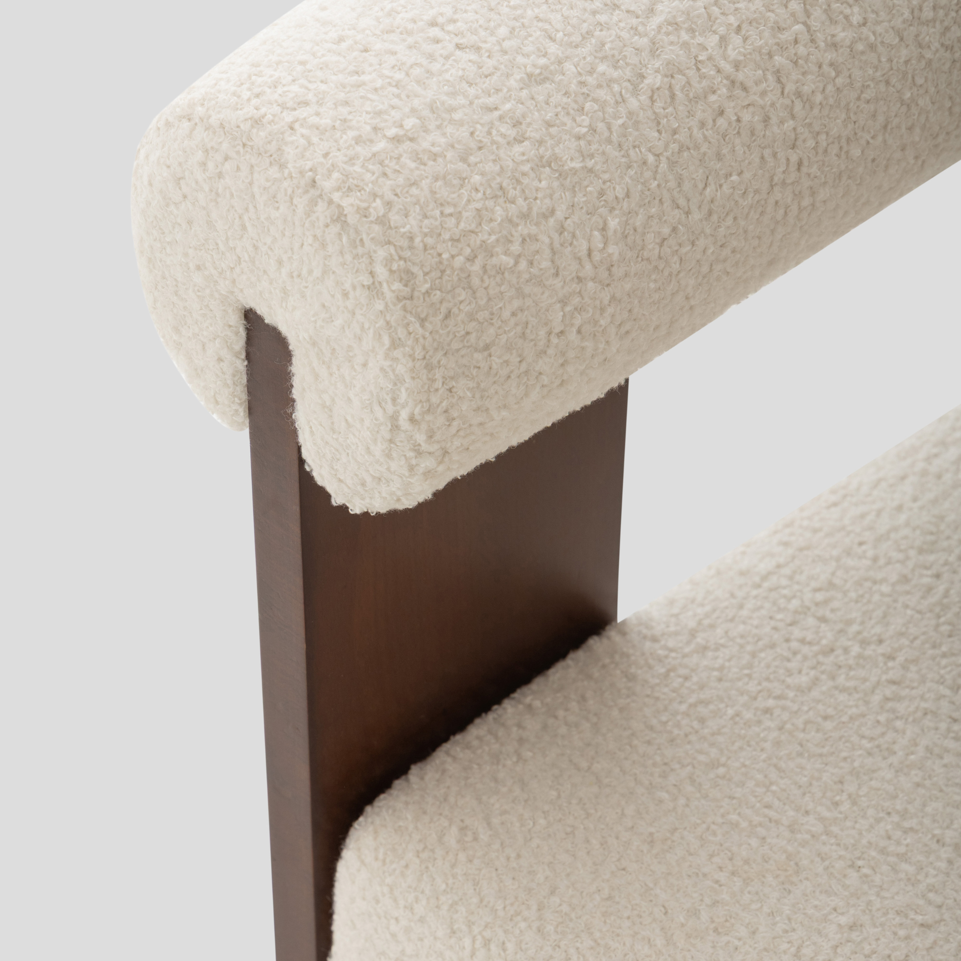 Ruby Curved Armchair in beech wood, featuring modern armchair and scandinavian styling, with cream and reading.