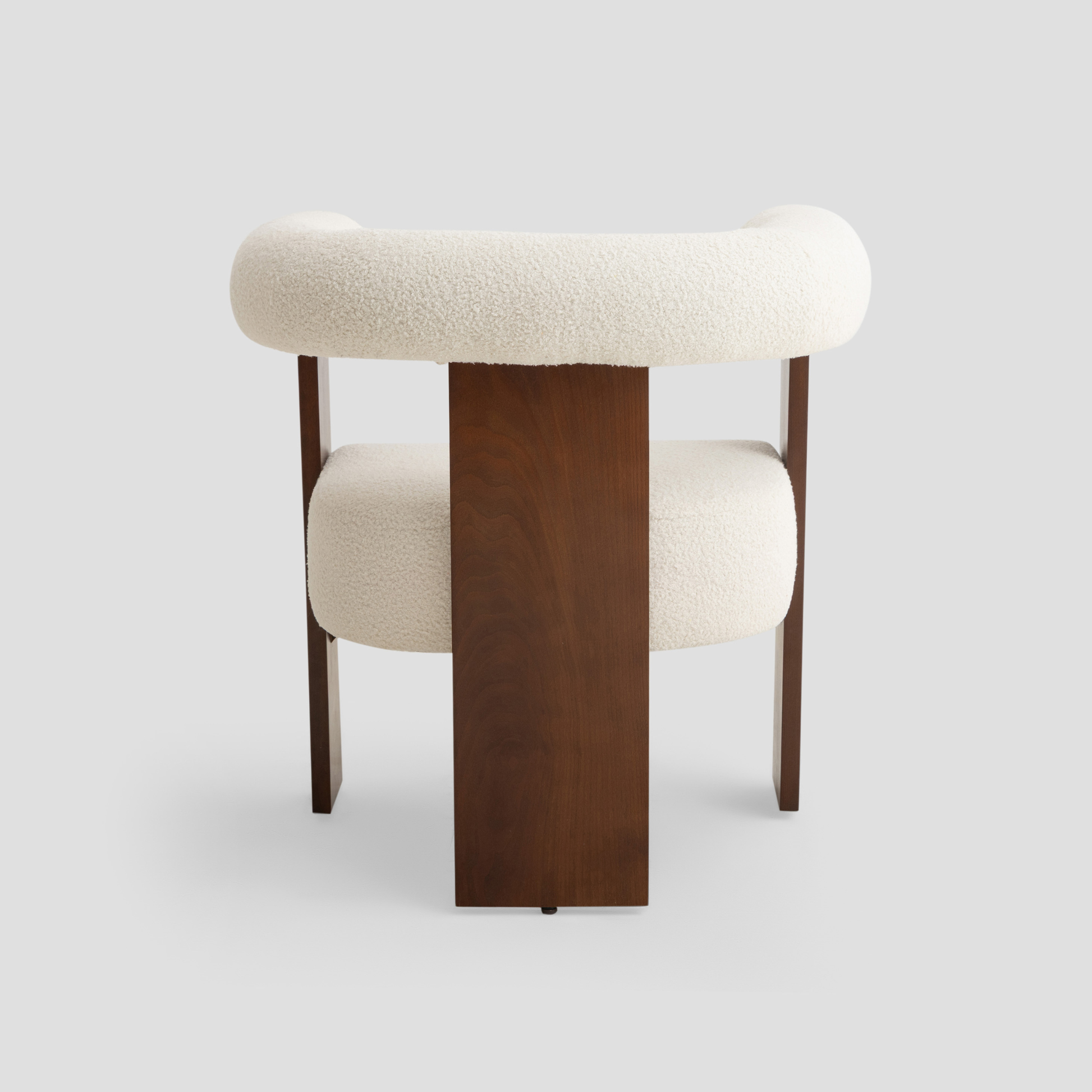 Ruby Curved Armchair in beech wood, featuring modern armchair and scandinavian styling, with cream and reading.